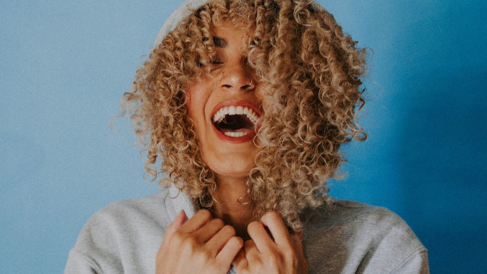 smiling woman wearing gray hoodie